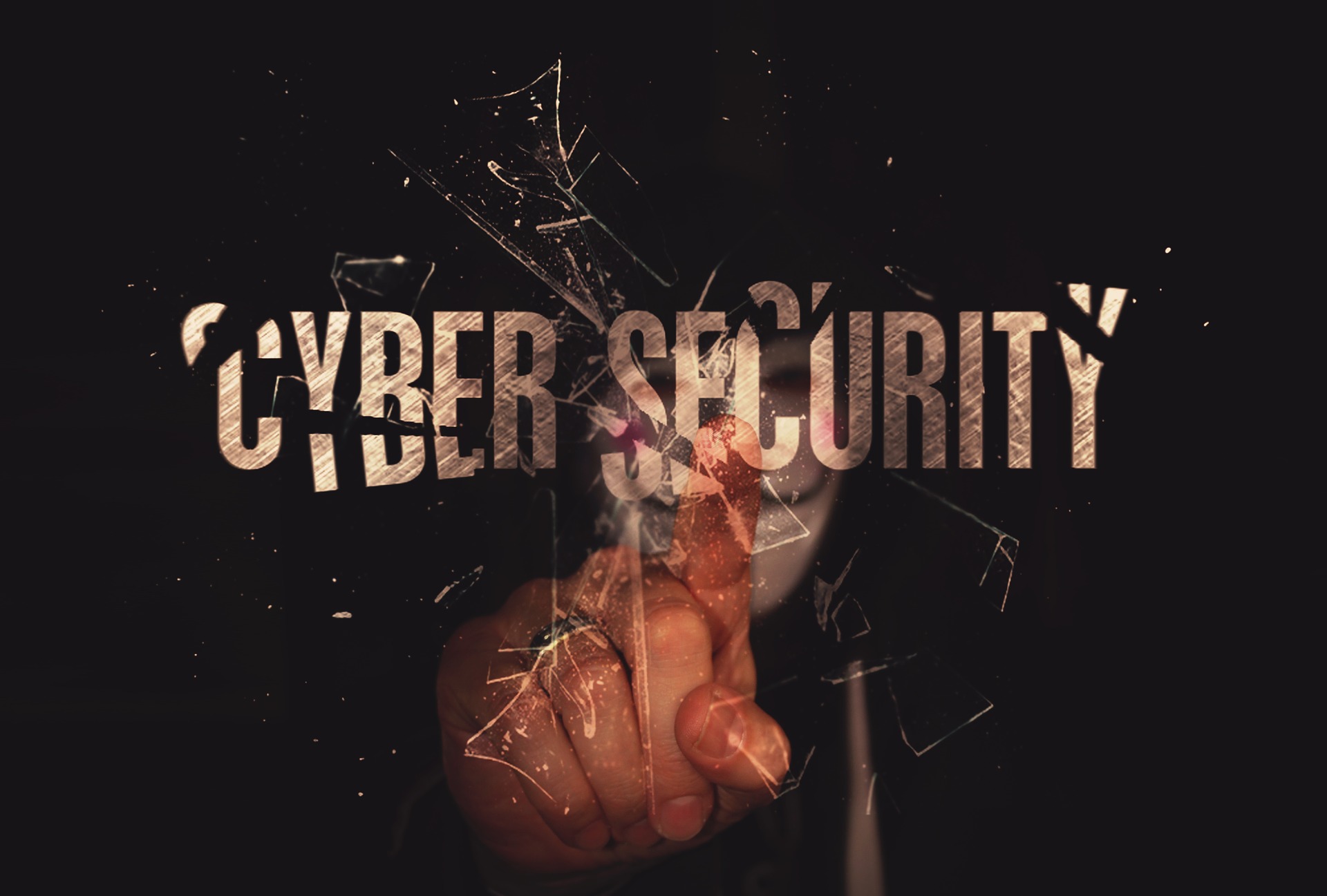 maskierter hacker zeigt auf den schriftzug cyber security